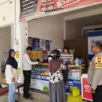 Bhabinkamtibmas Kelurahan Panarung, Aiptu Edi Prayitno, saat meninjau lokasi dugaan peredaran uang palsu di salah satu toko warga.